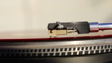 old Red vinyl record with clipping path. DJ Turntable with Vinyl Record, Playing, Top View. Close up at the needle on turntable