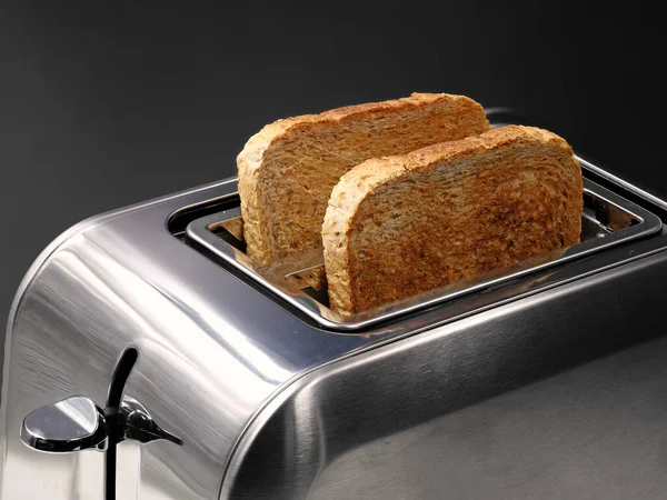 Torradeira cromada com fatias de pão integral isolado no fundo preto — Fotografia de Stock
