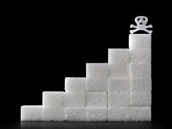 Сходи цукрового куба зі смертельним черепом на чорному тлі, надмірне споживання цукру може бути смертельним, концептуальне зображення — стокове фото