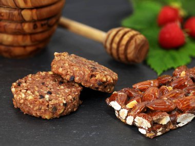 Badem çubuğu ve ballı ve meyveli müsli kurabiyeler yüksek lifli diyet için sağlıklı protein aperatifi..