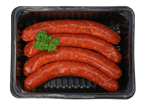 top view of raw spicy merguez sausages garnished with parsley in black plastic packaging.