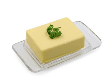 whole block butter on glass plate garnished with parsley isolated on white background.