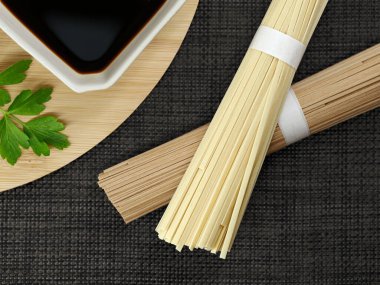 Soba ve soya soslu udon eriştesi pişirilmemiş porsiyon siyah arka planda geleneksel Japon kurutulmuş eriştesinin üst görüntüsü..