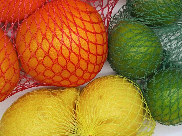 Apelsiner Limefrukter Och Citroner Nätpåse Plast Närbild Citrusfrukter Detaljhandelsförpackningar — Stockfoto