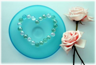 cam boncuk mavi cam plaka üzerinde bir kalp ile iki pembe güller