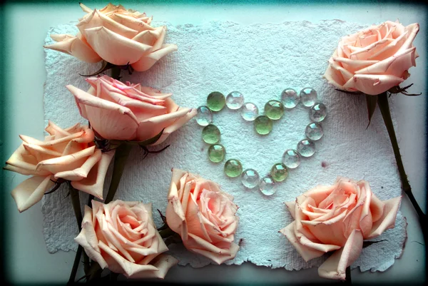 Grunge Hermosas rosas rosadas Fondo con un corazón de perlas de vidrio —  Fotos de Stock