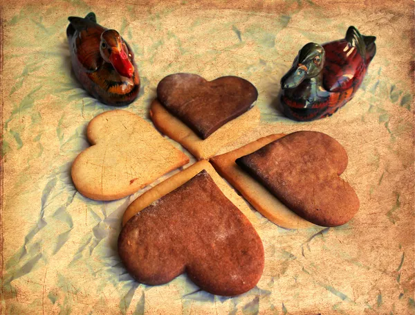 Valentines Day background with cookie hearts and old paper with red ribbon bow. Duck symbols of love. — Stock Photo, Image