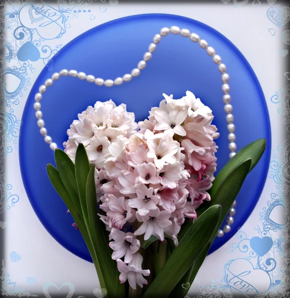 Deux fleurs de jacinthe avec une perle sur une plaque de verre bleu — Photo