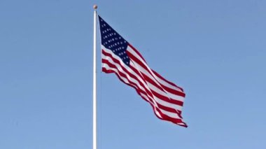 Mavi gökyüzü arka plan üzerinde rüzgarda uçan ABD bayrağı