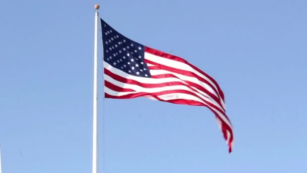 Bandeira dos EUA voando no vento no fundo azul do céu — Vídeo de Stock
