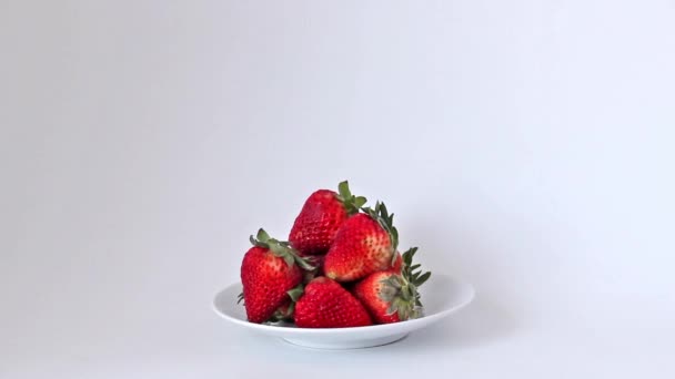 Hand taking strawberry out of bowl full of strawberries — Stock Video