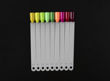 Siyah arka planda çok renkli tırnak uçları. Tırnaklar için manikür örneği. Çivi renk örnekleriyle palet. 