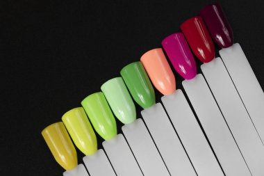 Beyaz arka planda çok renkli tırnak uçları. Tırnaklar için manikür örneği. Çivi renk örnekleriyle palet. 