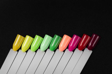 Beyaz arka planda çok renkli tırnak uçları. Tırnaklar için manikür örneği. Çivi renk örnekleriyle palet. 