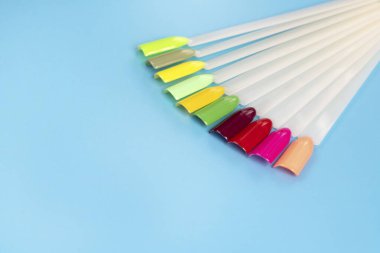 Beyaz arka planda çok renkli tırnak uçları. Tırnaklar için manikür örneği. Çivi renk örnekleriyle palet. 