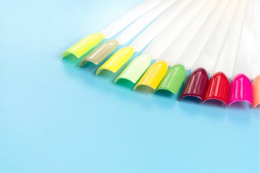 Beyaz arka planda çok renkli tırnak uçları. Tırnaklar için manikür örneği. Çivi renk örnekleriyle palet. 