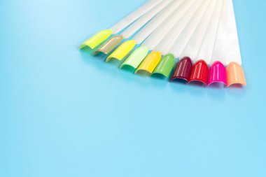 Beyaz arka planda çok renkli tırnak uçları. Tırnaklar için manikür örneği. Çivi renk örnekleriyle palet. 