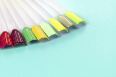 Beyaz arka planda çok renkli tırnak uçları. Tırnaklar için manikür örneği. Çivi renk örnekleriyle palet. 