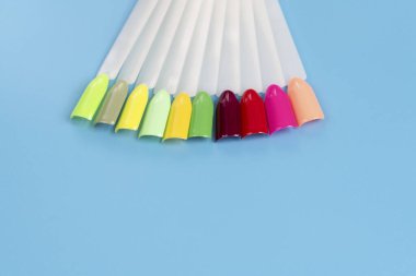 Beyaz arka planda çok renkli tırnak uçları. Tırnaklar için manikür örneği. Çivi renk örnekleriyle palet. 