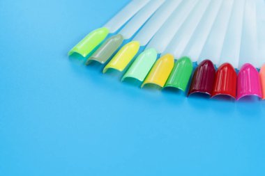 Beyaz arka planda çok renkli tırnak uçları. Tırnaklar için manikür örneği. Çivi renk örnekleriyle palet. 