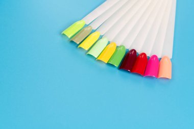 Beyaz arka planda çok renkli tırnak uçları. Tırnaklar için manikür örneği. Çivi renk örnekleriyle palet. 