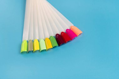 Beyaz arka planda çok renkli tırnak uçları. Tırnaklar için manikür örneği. Çivi renk örnekleriyle palet. 