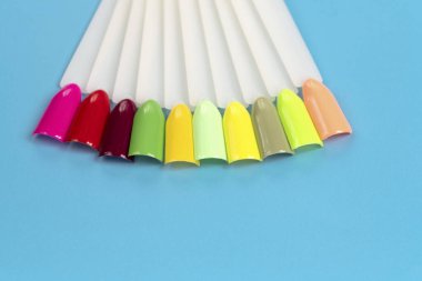 Beyaz arka planda çok renkli tırnak uçları. Tırnaklar için manikür örneği. Çivi renk örnekleriyle palet. 