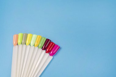 Beyaz arka planda çok renkli tırnak uçları. Tırnaklar için manikür örneği. Çivi renk örnekleriyle palet. 