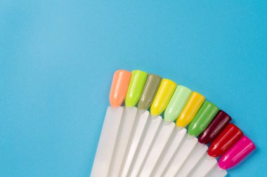 Beyaz arka planda çok renkli tırnak uçları. Tırnaklar için manikür örneği. Çivi renk örnekleriyle palet. 