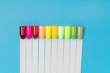 Beyaz arka planda çok renkli tırnak uçları. Tırnaklar için manikür örneği. Çivi renk örnekleriyle palet. 