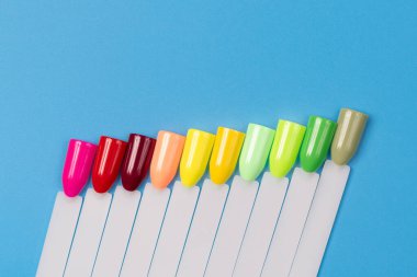 Beyaz arka planda çok renkli tırnak uçları. Tırnaklar için manikür örneği. Çivi renk örnekleriyle palet. 