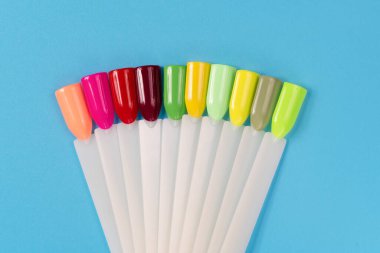 Beyaz arka planda çok renkli tırnak uçları. Tırnaklar için manikür örneği. Çivi renk örnekleriyle palet. 