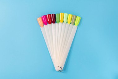 Beyaz arka planda çok renkli tırnak uçları. Tırnaklar için manikür örneği. Çivi renk örnekleriyle palet. 