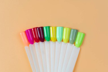 Beyaz arka planda çok renkli tırnak uçları. Tırnaklar için manikür örneği. Çivi renk örnekleriyle palet. 