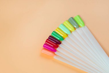 Beyaz arka planda çok renkli tırnak uçları. Tırnaklar için manikür örneği. Çivi renk örnekleriyle palet. 