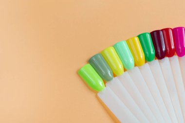 Beyaz arka planda çok renkli tırnak uçları. Tırnaklar için manikür örneği. Çivi renk örnekleriyle palet. 