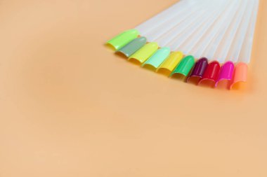 Beyaz arka planda çok renkli tırnak uçları. Tırnaklar için manikür örneği. Çivi renk örnekleriyle palet. 