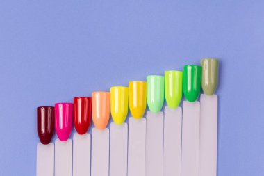 Beyaz arka planda çok renkli tırnak uçları. Tırnaklar için manikür örneği. Çivi renk örnekleriyle palet. 