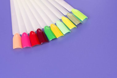 Beyaz arka planda çok renkli tırnak uçları. Tırnaklar için manikür örneği. Çivi renk örnekleriyle palet. 