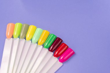 Beyaz arka planda çok renkli tırnak uçları. Tırnaklar için manikür örneği. Çivi renk örnekleriyle palet. 