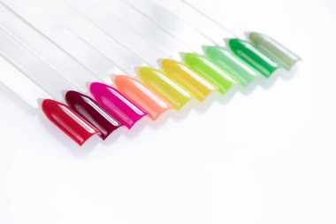 Beyaz arka planda çok renkli tırnak uçları. Tırnaklar için manikür örneği. Çivi renk örnekleriyle palet. 