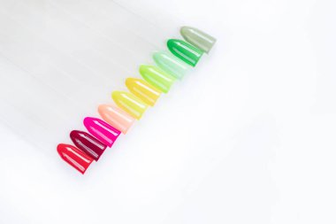 Beyaz arka planda çok renkli tırnak uçları. Tırnaklar için manikür örneği. Çivi renk örnekleriyle palet. 