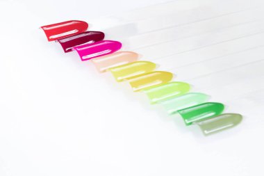 Beyaz arka planda çok renkli tırnak uçları. Tırnaklar için manikür örneği. Çivi renk örnekleriyle palet. 