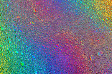 Çeşitli renklerdeki yağ ve su kabarcıklarının soyut görüntüsü. Modern tasarım arka planı için suyun üzerindeki yağ damlasının renkli sanatsal görüntüsü