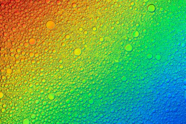 Çeşitli renklerdeki yağ ve su kabarcıklarının soyut görüntüsü. Modern tasarım arka planı için suyun üzerindeki yağ damlasının renkli sanatsal görüntüsü