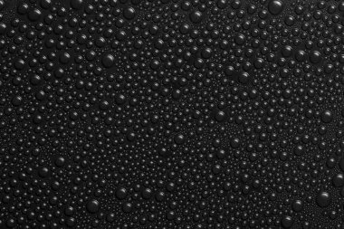 Siyah arkaplan dokusuna su damlaları. Su damlalarıyla kaplı koyu renk bir arka plan camı. Suda siyah kabarcıklar