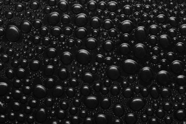 Siyah arkaplan dokusuna su damlaları. Su damlalarıyla kaplı koyu renk bir arka plan camı. Suda siyah kabarcıklar