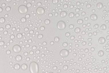 Beyaz arkaplan dokusuna su damlaları. Arkaplan camı su damlalarıyla kaplı. Sudaki gri kabarcıklar