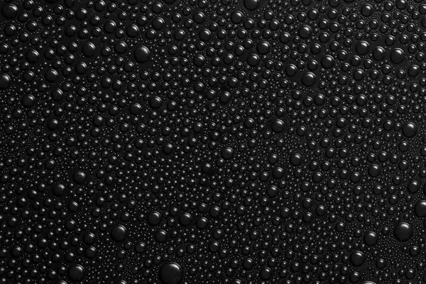 黒の背景の質感に水が落ちる 暗い背景ガラスは水の滴で覆われています 水の中の黒い泡 — ストック写真