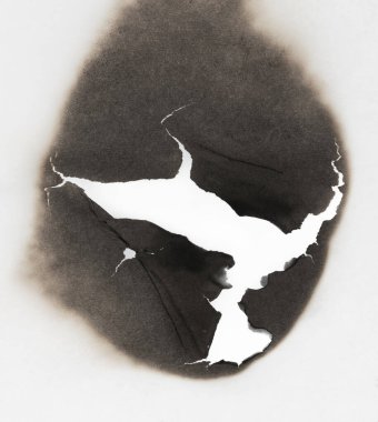 Beyaz kağıtta izole edilmiş yanmış bir delik. Yanan sınırlar kağıdı kapat